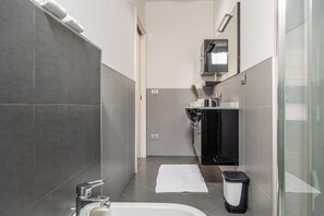 Een moderne badkamer met een bad, toilet, wastafel en spiegel.