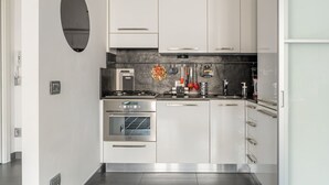 A modern kitchen with white cabinets, a built-in oven, a stove, and a microwave. - GuestHost - Charming apartment of about 50 square meters, perfect for two people, located on the first floor of a building with a lift (NOT suitable for disabled people).The property is located in the heart of the historic center of Verona, a few steps f (Verona)