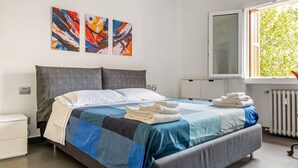 A modern hotel room with a large bed, a window with a view of trees, and abstract art on the wall. - GuestHost - Charming apartment of about 50 square meters, perfect for two people, located on the first floor of a building with a lift (NOT suitable for disabled people).The property is located in the heart of the historic center of Verona, a few steps f (Verona)
