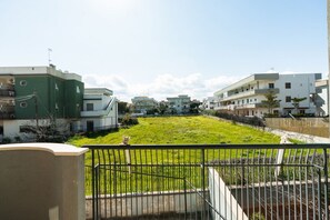 Een woongebied met meerdere appartementencomplexen, een gazon en een metalen hek.