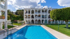 Une piscine avec un bâtiment blanc en arrière-plan.