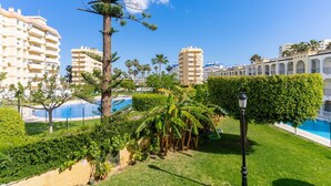 Un complexe hôtelier doté d’une piscine, de palmiers et de bâtiments modernes.