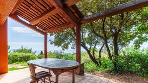 A wooden pergola with a table and chairs, overlooking a scenic view of trees and a body of water. - Holiday Home 'Catherine Vue Mer Et Terrasse' with Sea View, Private Terrace and Wi-Fi (Carqueiranne)