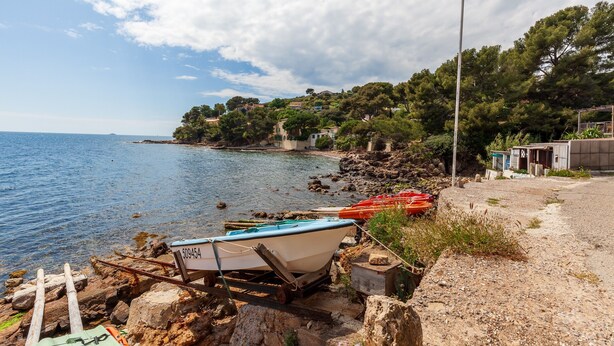 A coastal scene with a boat on a trailer, rocky shore, and buildings in the background. - Holiday Home 'Catherine Vue Mer Et Terrasse' with Sea View, Private Terrace and Wi-Fi (Carqueiranne)