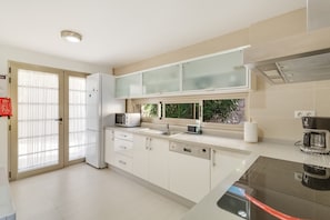 A modern kitchen with a dishwasher, microwave, and coffee maker. - Vacation 'Pure Luxury and Comfort La Oliva' with Mountain View, Wi-Fi and Air Conditioning (La Playa de Tauro)