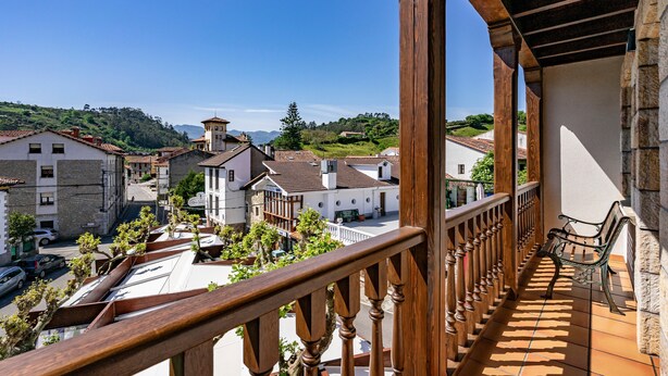 A balcony with a wooden railing overlooking a residential area with houses and greenery. - Apartment 'Cantu' with Private Terrace, Balcony and Wi-Fi (Bustio)