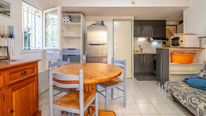 A compact living space with a dining area, kitchen, and seating area. - Holiday Home 'Hameau Du Soleil' with Shared Pool, Private Terrace and Private Garden (Vendres)