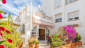 A courtyard with potted plants, a staircase, and a building entrance. - Apartment 'Finca 9' with Shared Pool, Wi-Fi and Air Conditioning (Moraira)