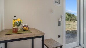 Ein Zimmer mit Tisch, einem Honigglas, einer Schüssel und einer Topfpflanze.