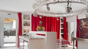 A modern interior with a central island, red curtains, and a ceiling with lighting fixtures. - Apartment 'Le Loft' with Mountain View, Wi-Fi and Air Conditioning (Cannes)
