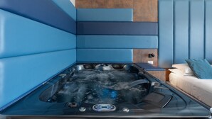 Ein moderner Spa-Bereich mit Whirlpool, einem Bett und einer an der Wand befestigten Massageliege.