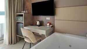 Une salle de bain moderne équipée d’une baignoire, d’un meuble-lavabo avec un téléviseur à écran plat, d’une machine à café et d’une chaise.