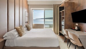 A hotel room with a bed, a desk, a TV, and a view of the sea. - Room 'Luxury  Fronte Mare Con Jacuzzi' with Balcony, Wi-Fi and Air Conditioning (Napoli)