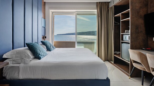 Ein modernes Hotelzimmer mit einem großen Bett, einem Schreibtisch und einem Kleiderschrank.