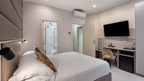A modern hotel room with a large bed, a desk, a chair, a television, and an air conditioning unit. - Room Suite with Private Pool, Wi-Fi, and Air Conditioning (Napoli)
