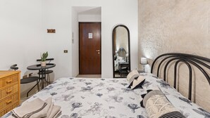 Un dormitorio con cama, cómoda, espejo y una mesita con silla.