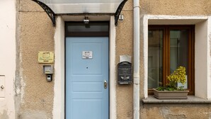 A blue door with a sign, a mailbox, and a window with a planter. - Room 'Camera 2' with Wi-Fi and Air Conditioning (Oristano)
