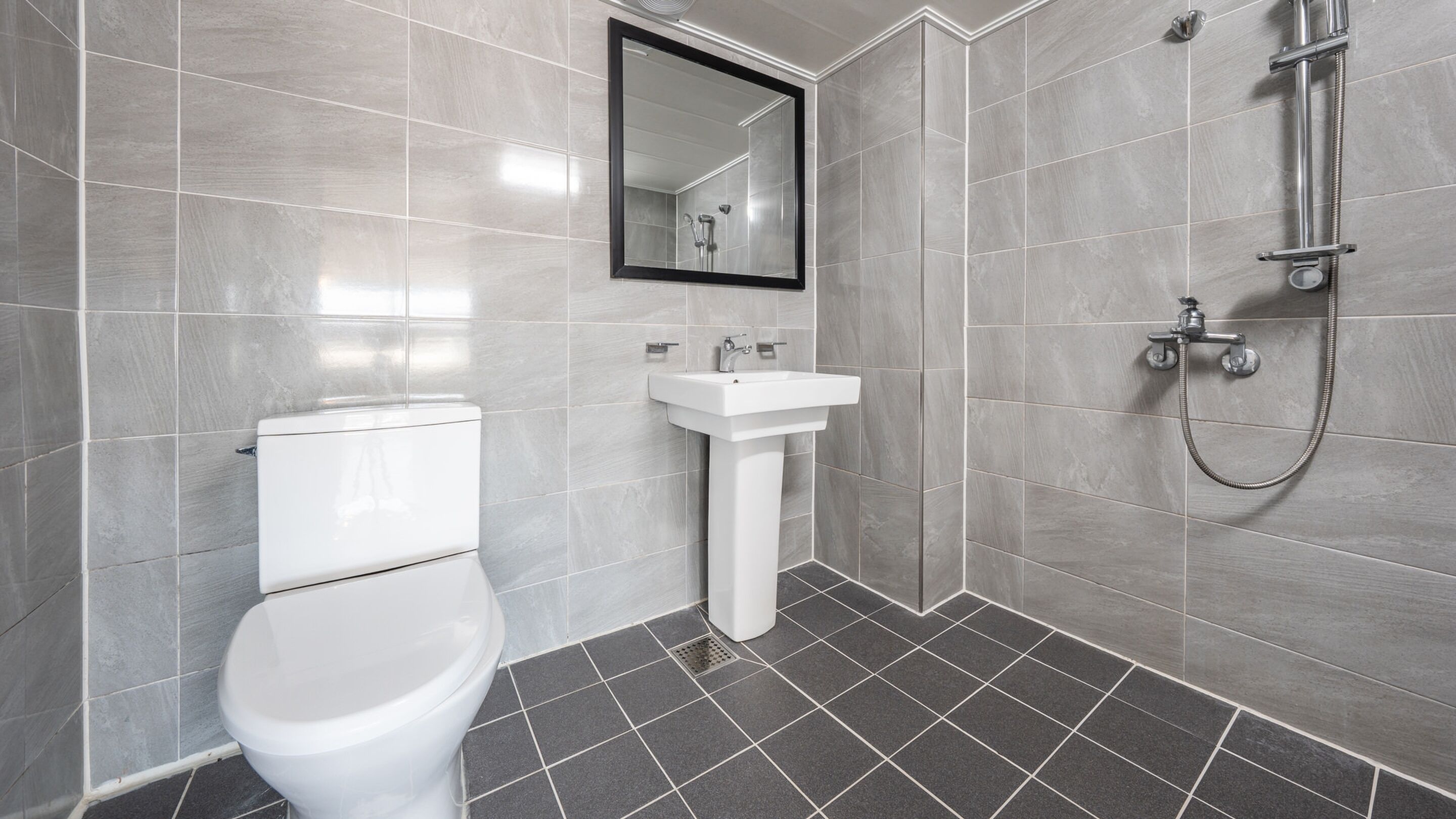 A modern bathroom with a toilet, sink, and shower.