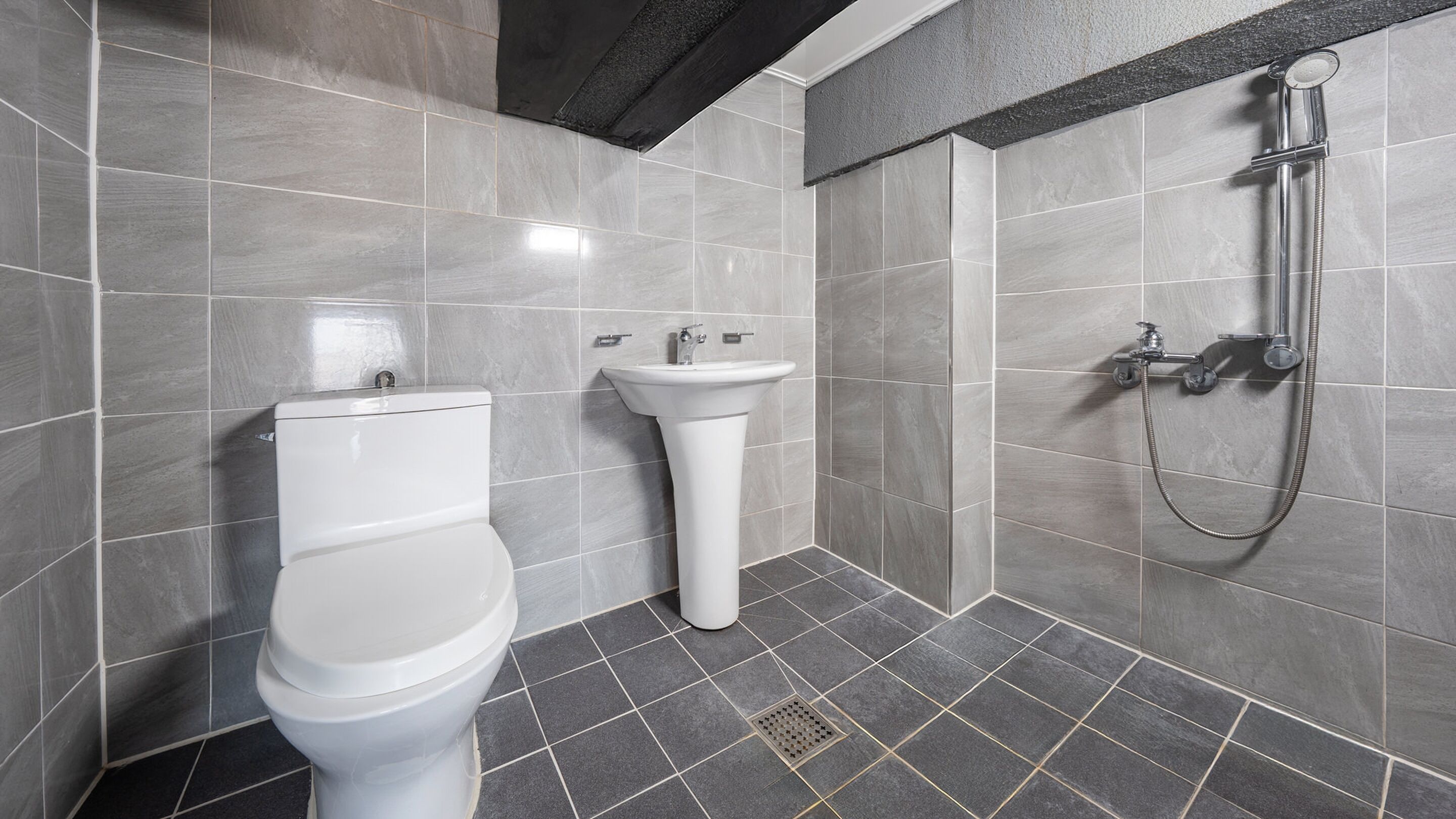 Ein modernes Badezimmer mit Toilette, Waschbecken und Dusche.