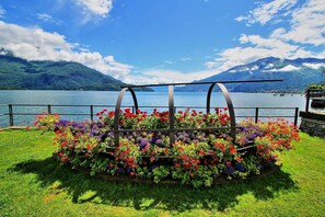 A garden with colorful flowers and a view of a lake and mountains.