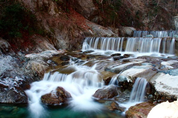 Une cascade d’eau qui dévale des rochers dans un environnement naturel.