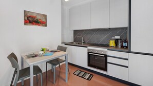 Een moderne keuken met witte kasten, een zwart aanrecht, een fornuis en een spoelbak.
