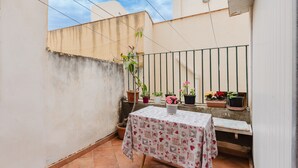 A small patio with a table and potted plants.