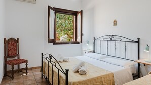 A bedroom with a bed, a chair, a window, and a desk with a lamp. - Apartment 'Tra Mare E Natura, Solo Relax' with Mountain View, Wi-Fi and Air Conditioning (Castelluzzo)