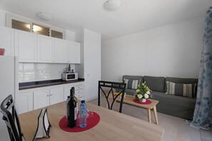 A compact living space with a kitchenette, dining area, and a sofa.
