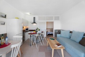 A compact living space with a kitchenette, dining area, and a sofa. - Apartment 'Playa Azul - 5' with Sea View, Wi-Fi and Air Conditioning (Vallehermoso)
