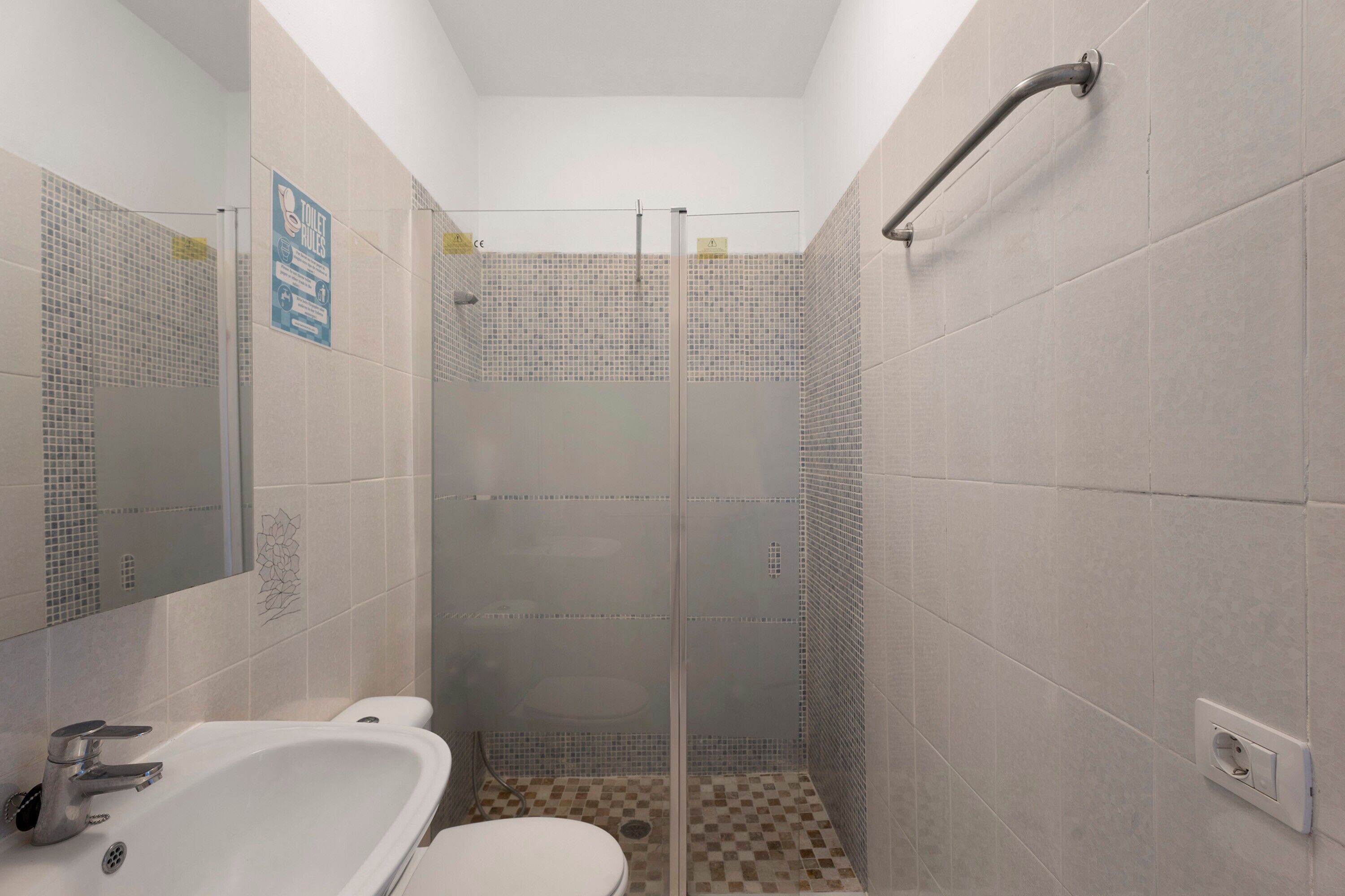 Un bagno dotato di doccia, WC e lavandino.