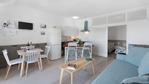 A compact living space with a dining area, kitchenette, and a bed. - Apartment 'Playa Azul - 2' with Sea View, Wi-Fi, and Air Conditioning (Vallehermoso)