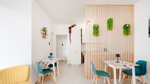 A modern dining area with two tables, chairs, and a yellow sofa. - Room 'Volutta' with Shared Terrace, Wi-Fi and Air Conditioning (Conversano)