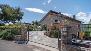 Una casa de piedra con un portón de piedra, un camino de entrada pavimentado y un letrero con el número 41.