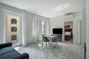 A modern living room with a dining area, a TV, and a sofa.