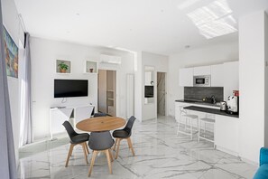 Una cocina moderna con microondas, cafetera y lavabo.