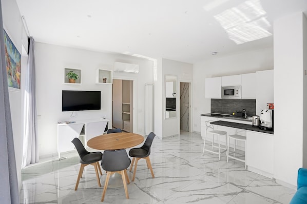 A modern kitchen with a microwave, a coffee maker, and a sink.