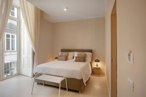 Een slaapkamer met een bed, nachtkastjes, een raam met gordijnen en uitzicht.