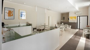 A modern hotel lobby with a reception desk, white chairs, a dining area, and artwork on the walls. - Room 'San Severo' with Balcony, Wi-Fi and Air Conditioning (Napoli)