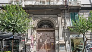 Un edificio con una puerta grande de madera, un balcón con barandillas ornamentales y una fachada con el nombre 'Starlet'.