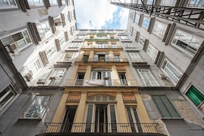Un edificio de varios pisos con balcones, grandes ventanales y una entrada central.
