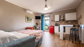 En moderne lejlighed med seng, sofa, et køkken og et spisebord.