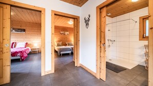 A wooden interior with a bed, a shower, and a wall-mounted deer head decoration. - Cottage 'Côté Giffre' with Lake View, Private Terrace and Wi-Fi (Châtillon-sur-Cluses)
