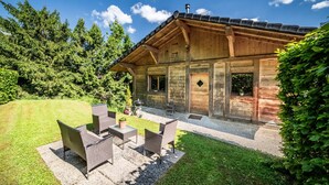 A wooden cabin with a patio, outdoor furniture, and a view of the surrounding forest. - Cottage 'Leyetaz' with Lake View, Private Terrace and Wi-Fi (Châtillon-sur-Cluses)