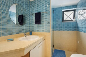 Ein Badezimmer mit Waschbecken, Spiegel und Handtuchhalter.