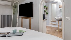 Une chambre à coucher avec un lit, une télévision, un radiateur et une fenêtre.