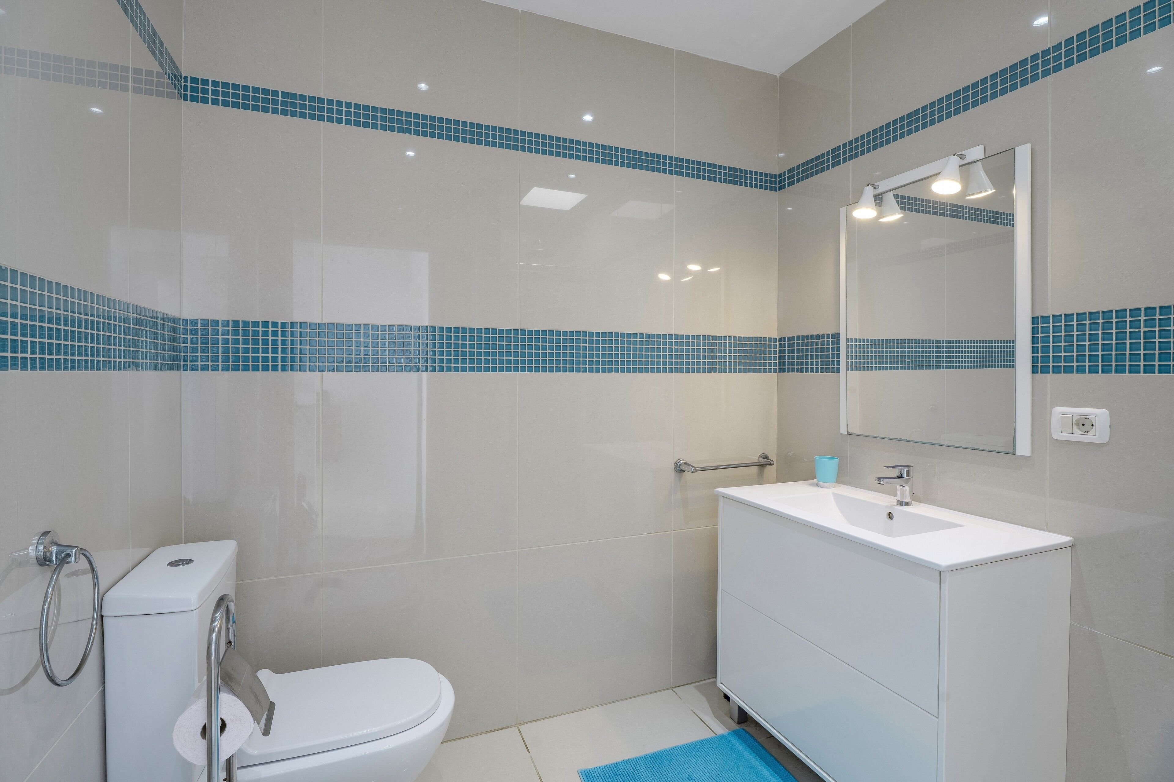A bathroom with a toilet, sink, and shower.