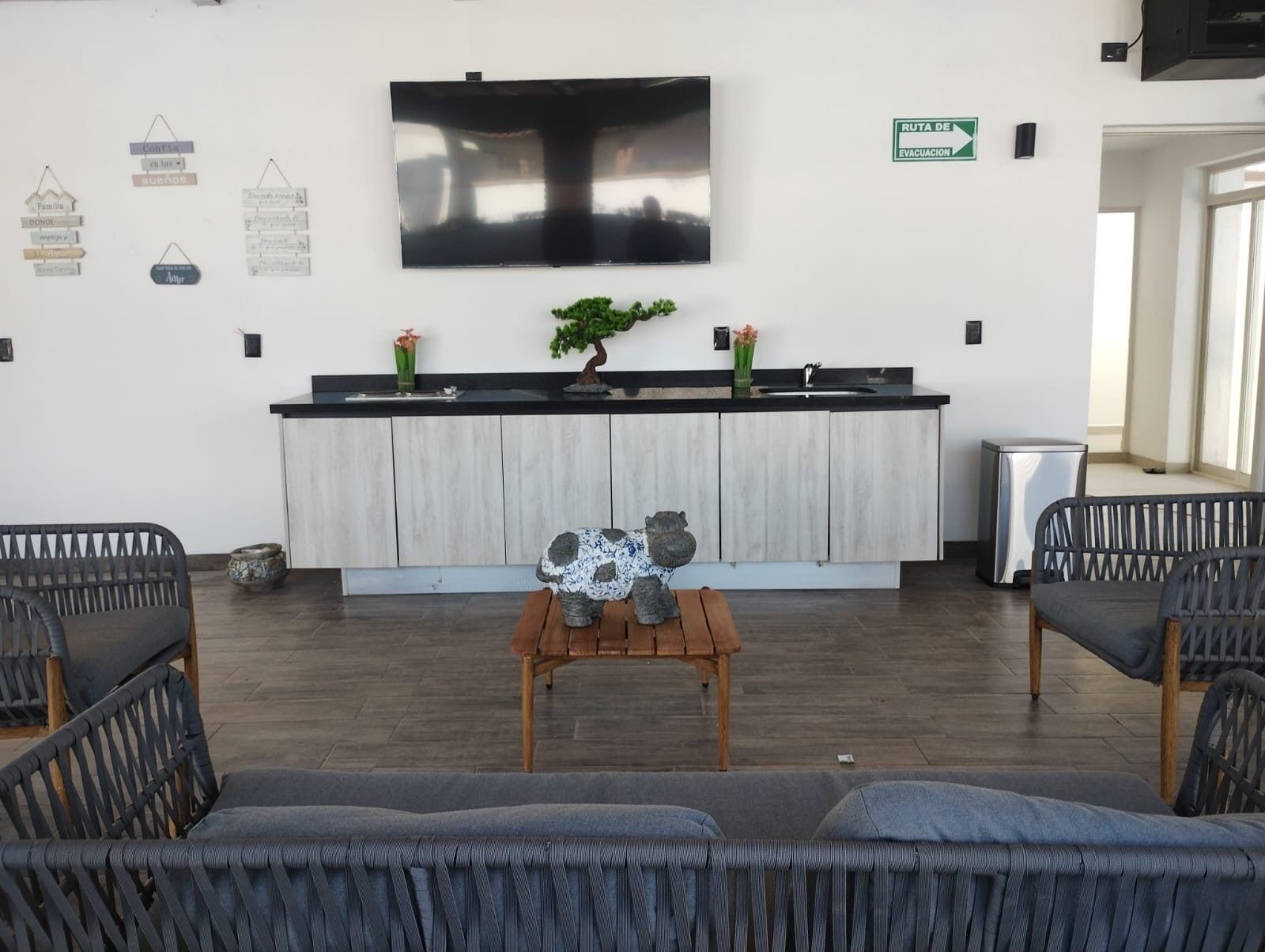 Ein modernes Interieur mit Kücheninsel, Sitzgruppe und einem an der Wand befestigten Fernseher.
