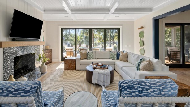 A spacious living room with a fireplace, a large flat-screen TV, and a comfortable seating area with a sofa and chairs.
