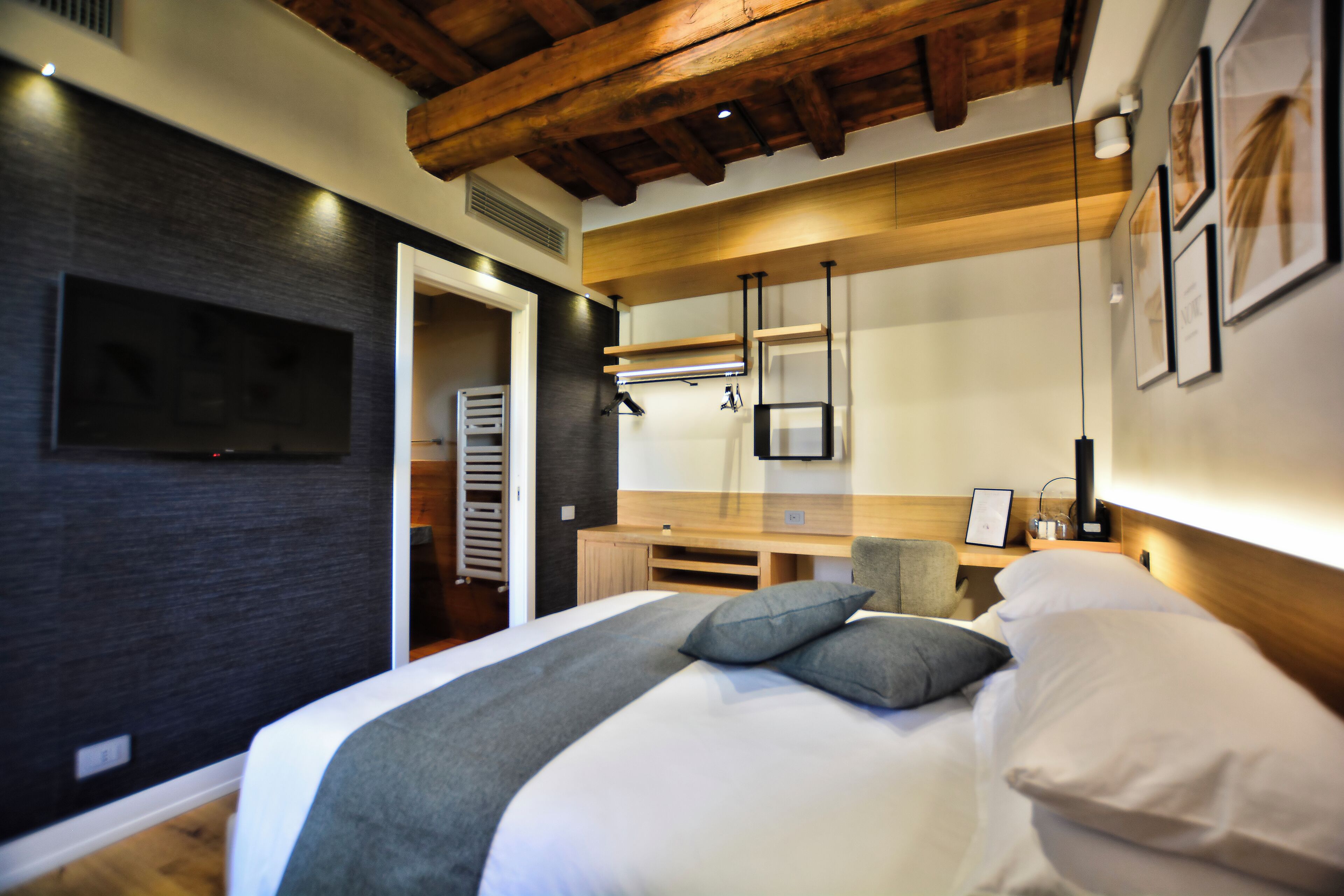 Een moderne slaapkamer met een groot bed, een bureau en een kledingkast.